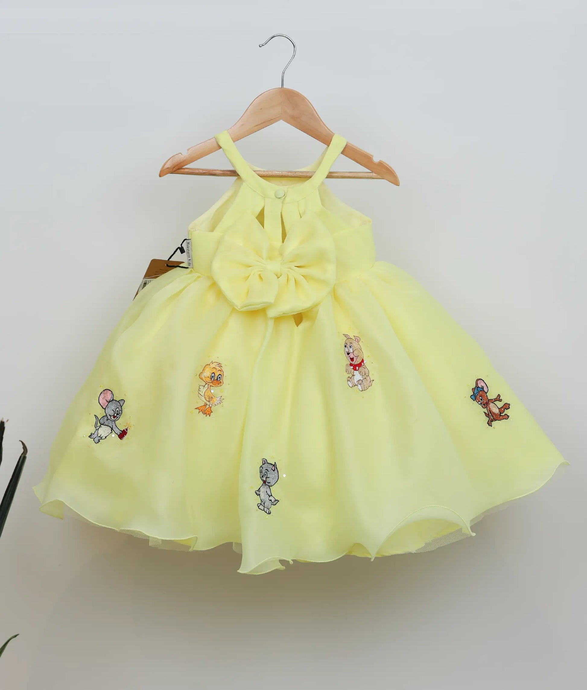 Back view of yellow plain organza tom and Jerry-themed birthday dress for baby girl 