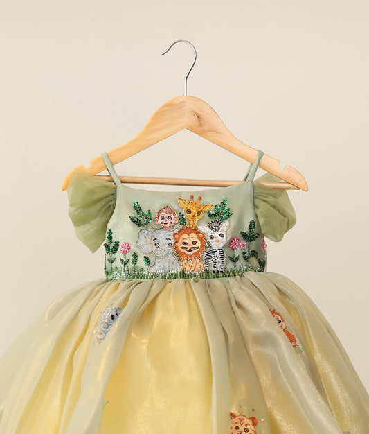 Close view of pastel green floral embroidery on a jungle-themed birthday dress for baby girl 