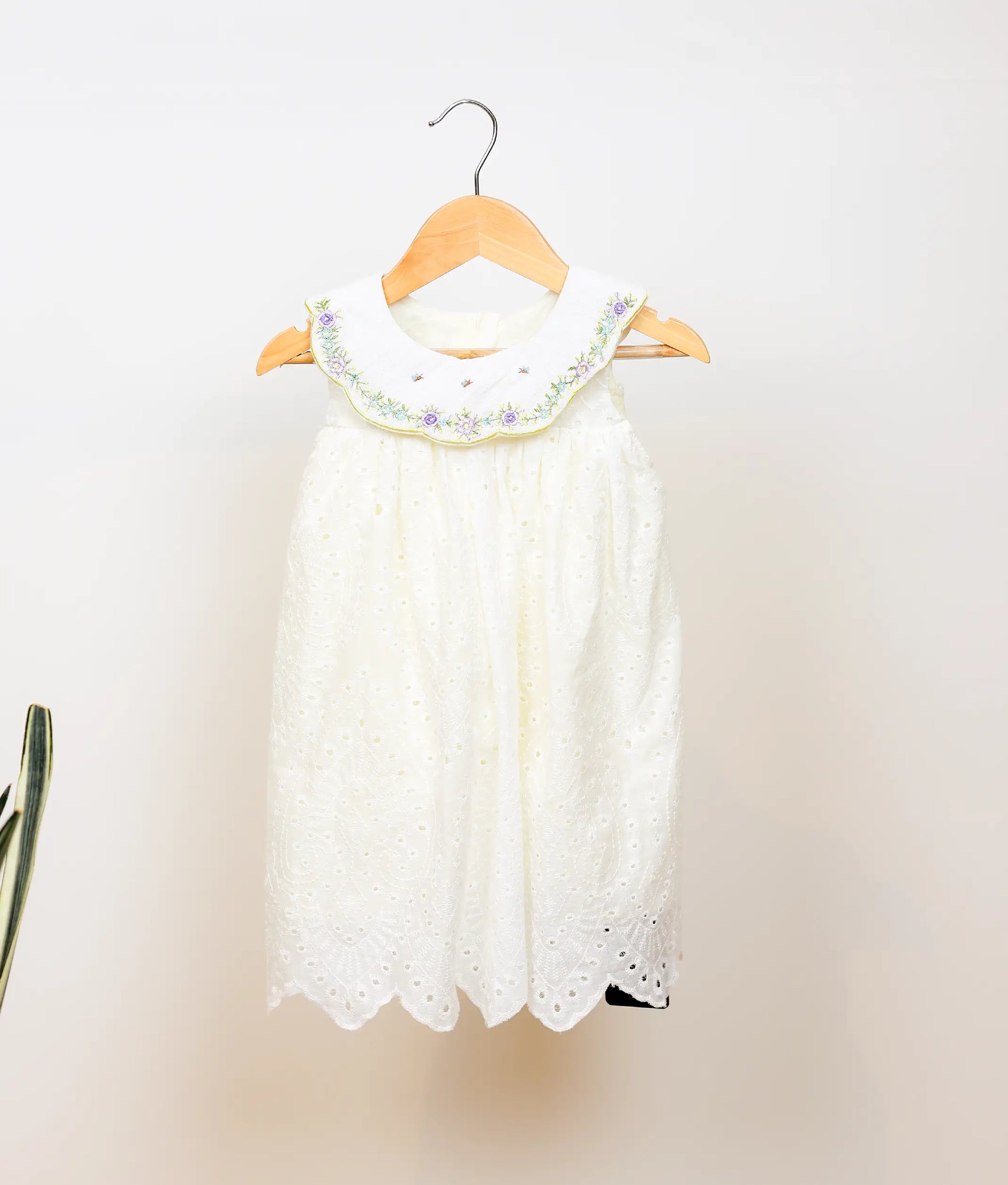 Front view of an off-white hacoba a-line christmas frock against plain background