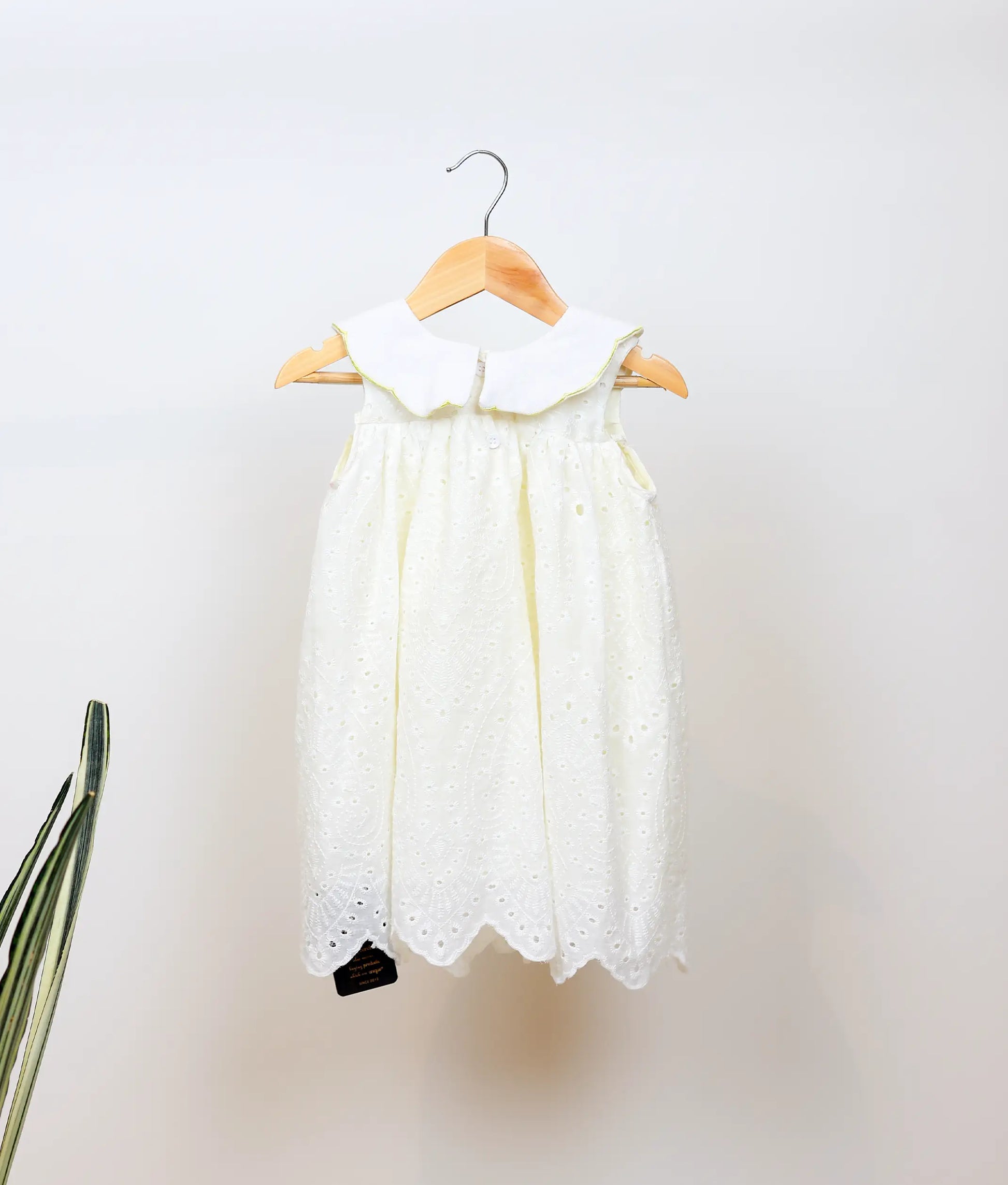 Back view of an off-white hacoba a-line christmas frock against plain background