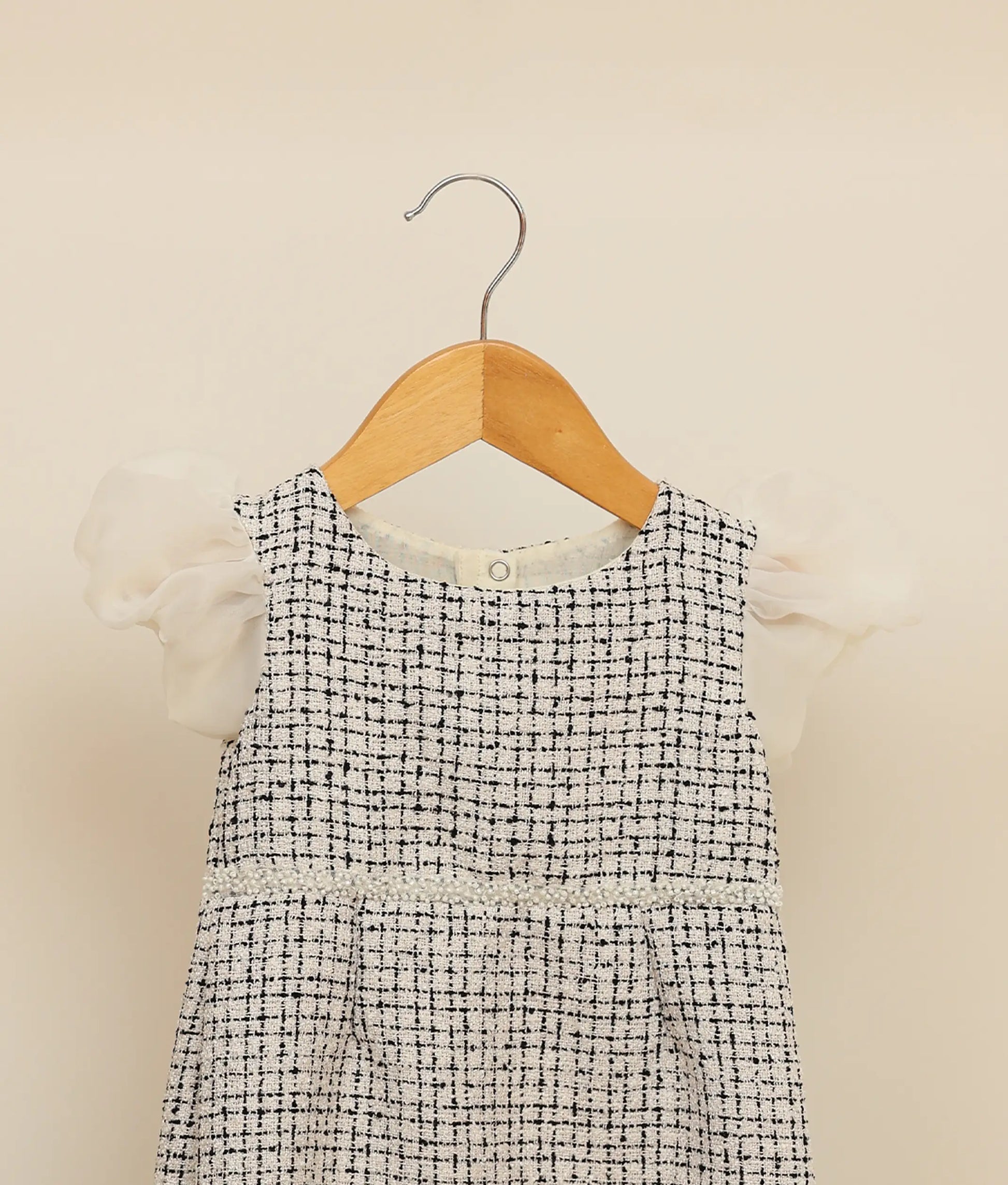 Close view of black and white handworked tweed-fish cut frock against plain background 