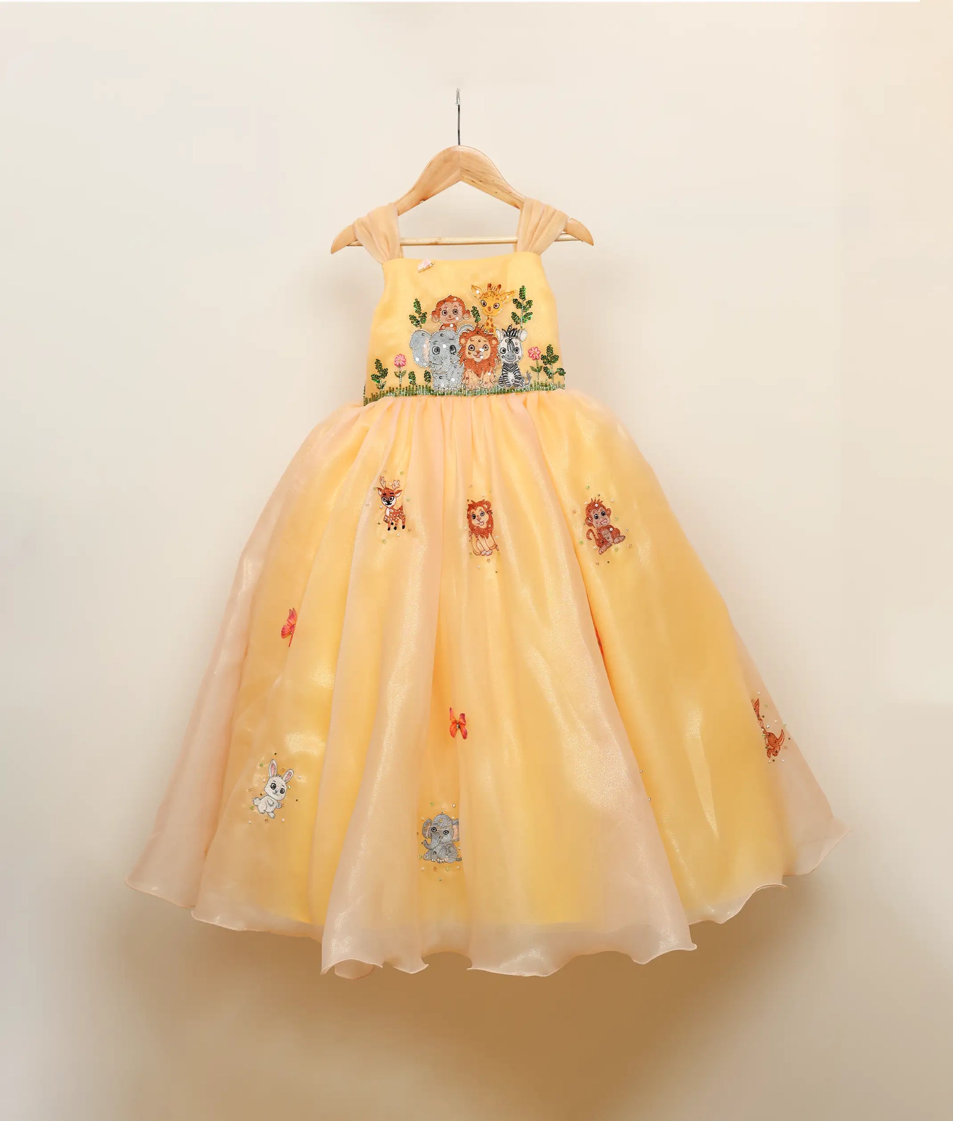 Front view of Golden yellow jungle-themed birthday gown against plain background