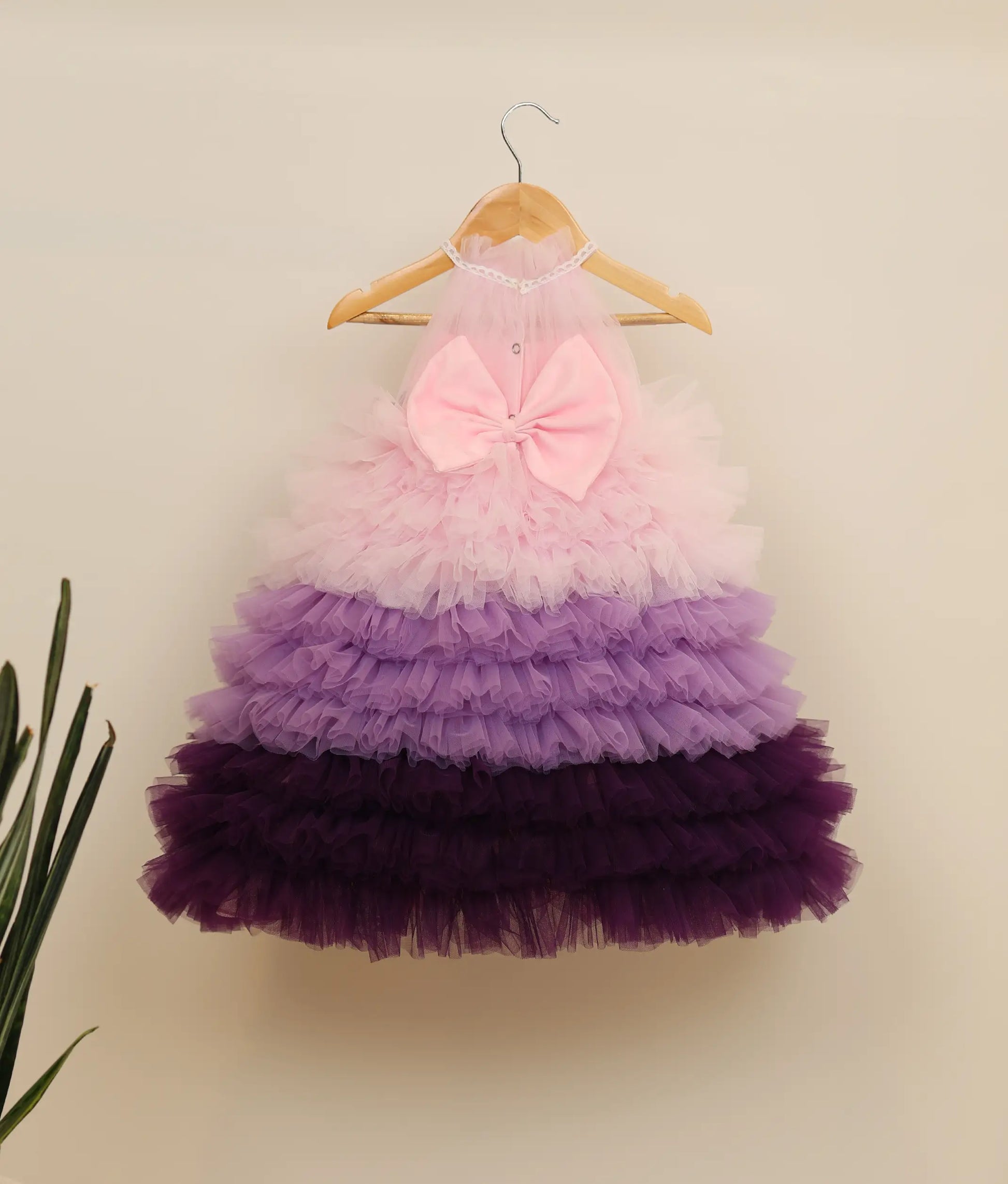 Back view of multi-color tulle net handworked step gown against plain background