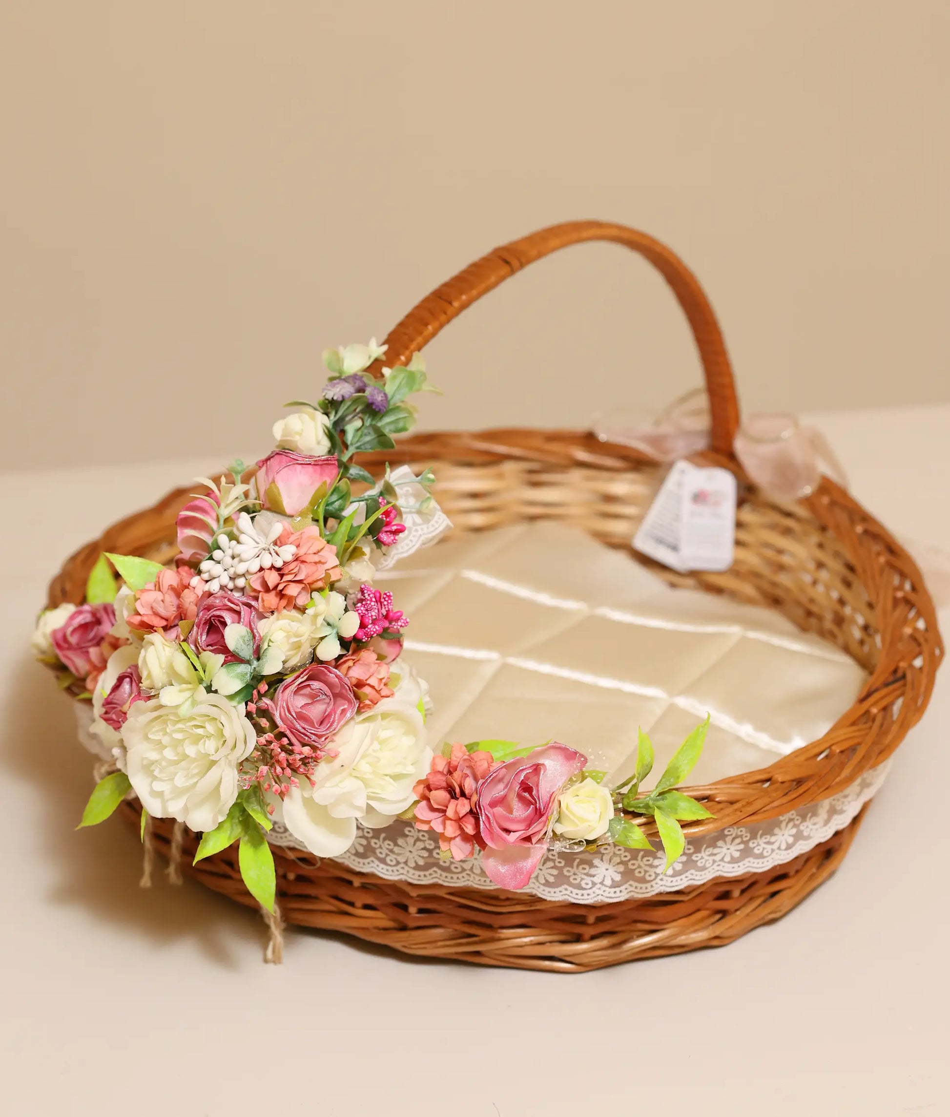 Pink and off-white flower baptism wicker basket against plain background