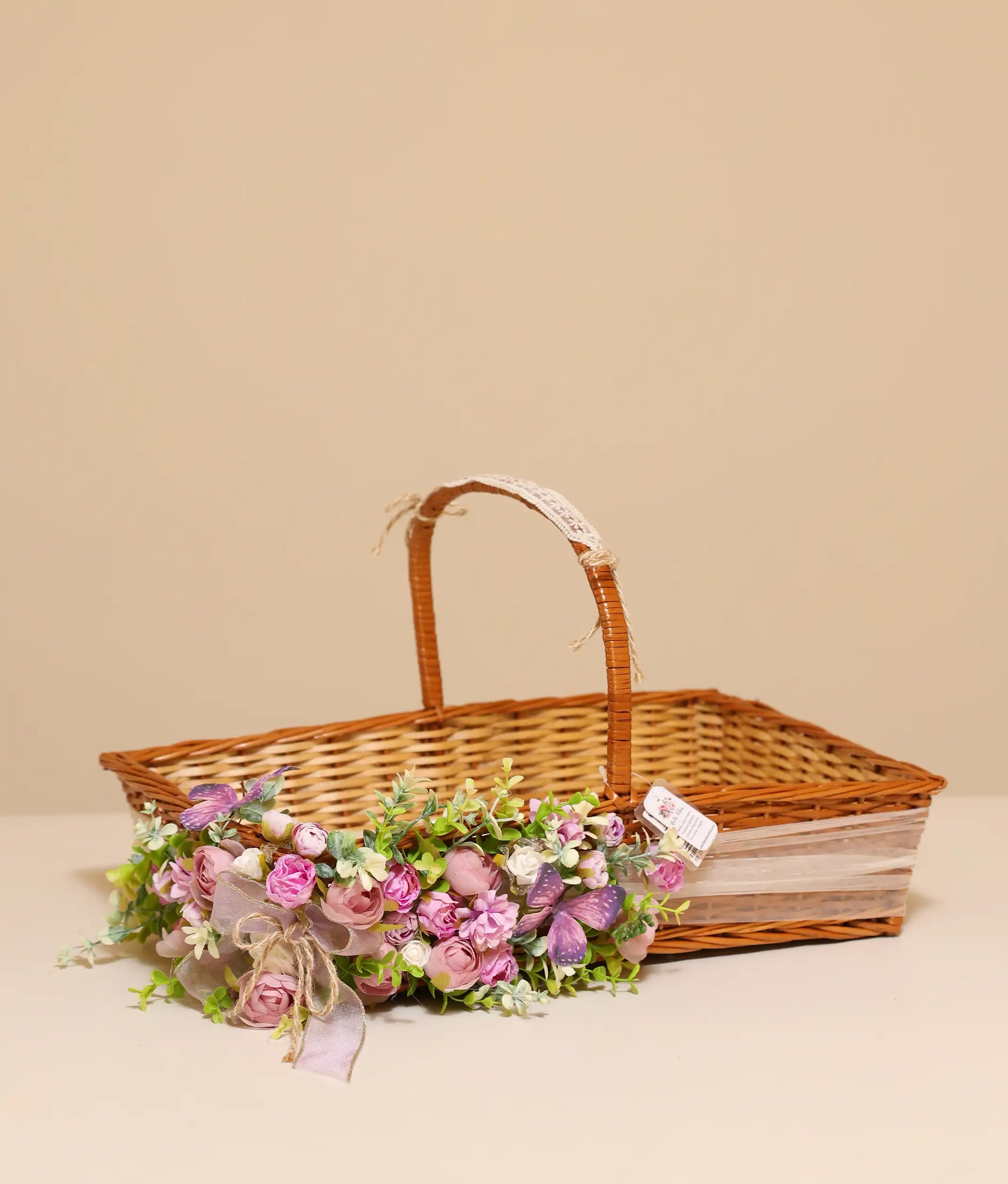 Pink flower wicker basket against plain background