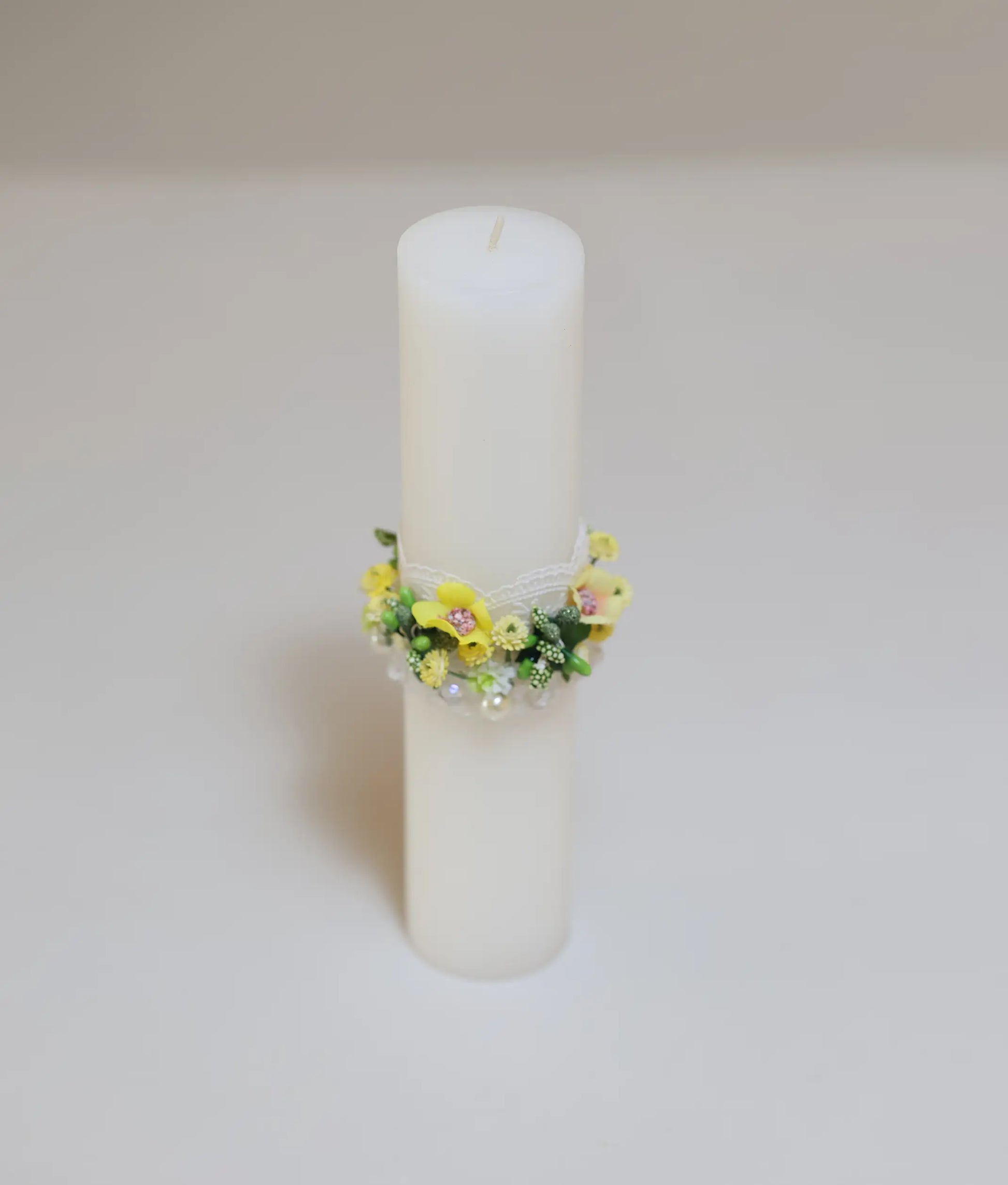 Close view of a yellow floral flower pillar candle for your baby baptism 