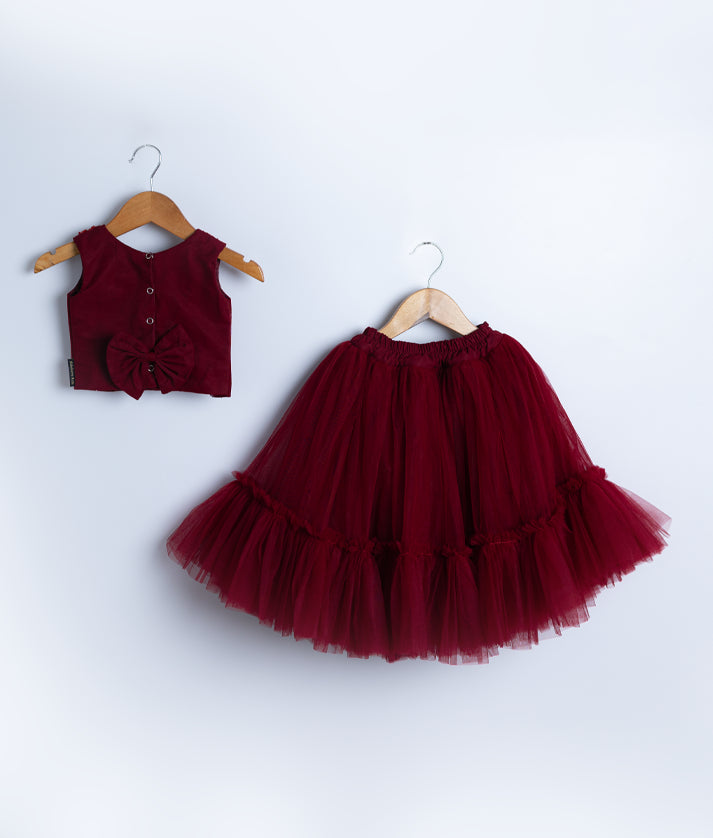 Back view of an maroon tulle net handworked skirt and top set displayed against a white background.