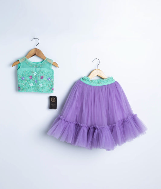 Ocean green handwork top with lavender skirt for a baby girl, displayed on hangers against a white background.