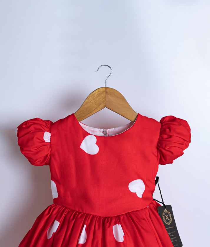 Close view of an red chiffon frock displayed on a hanger.