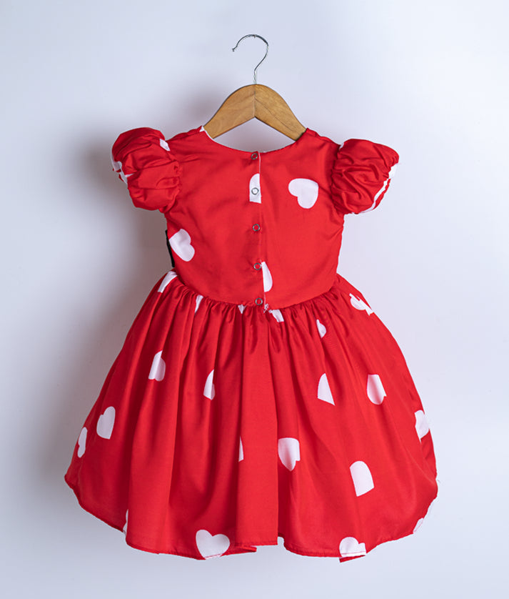 Back view of an red chiffon frock displayed on a hanger.
