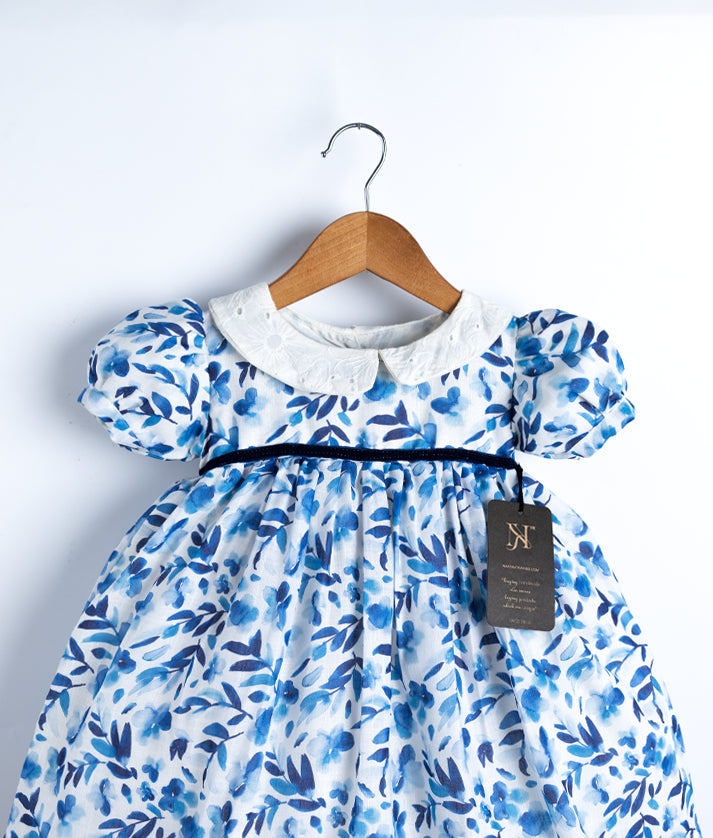 Close view of blue and white printed cotton frock displayed on a hanger.