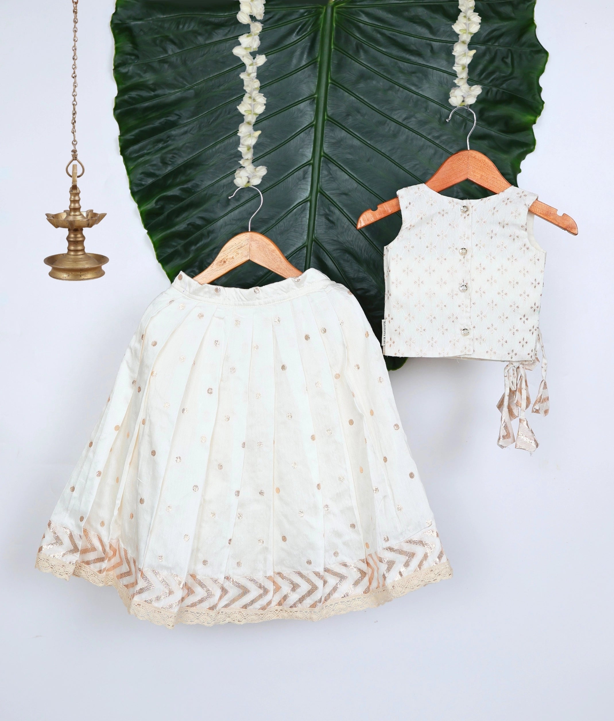 Off-white outfit with a green leafy background.