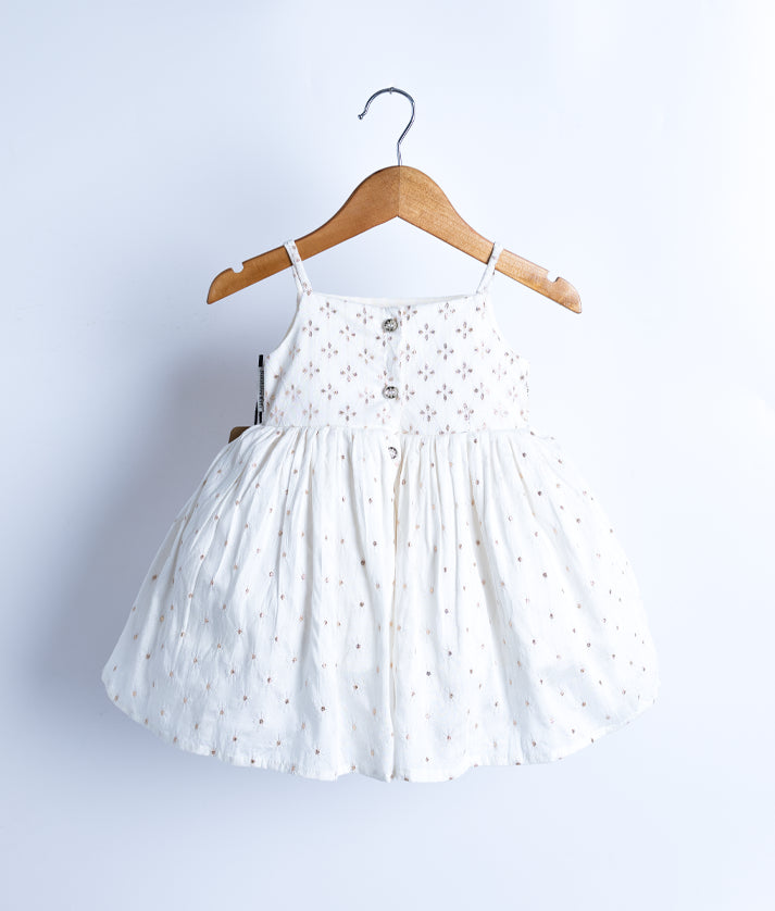 Back view of an off-white, sleeveless, flared frock displayed on a wooden hanger against a white background.