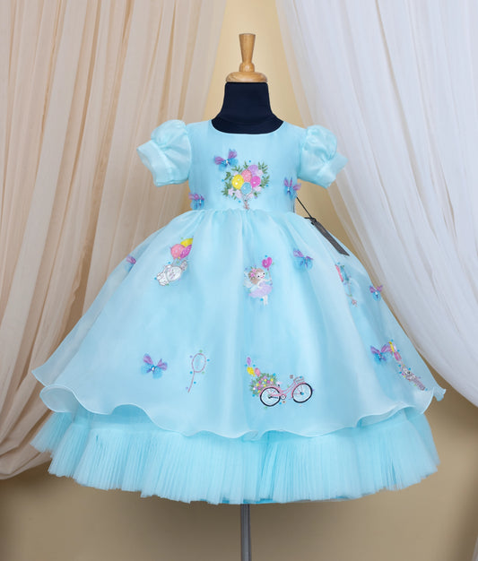 Sky blue dress with baloon designs on a mannequin against a beige and white curtain background.