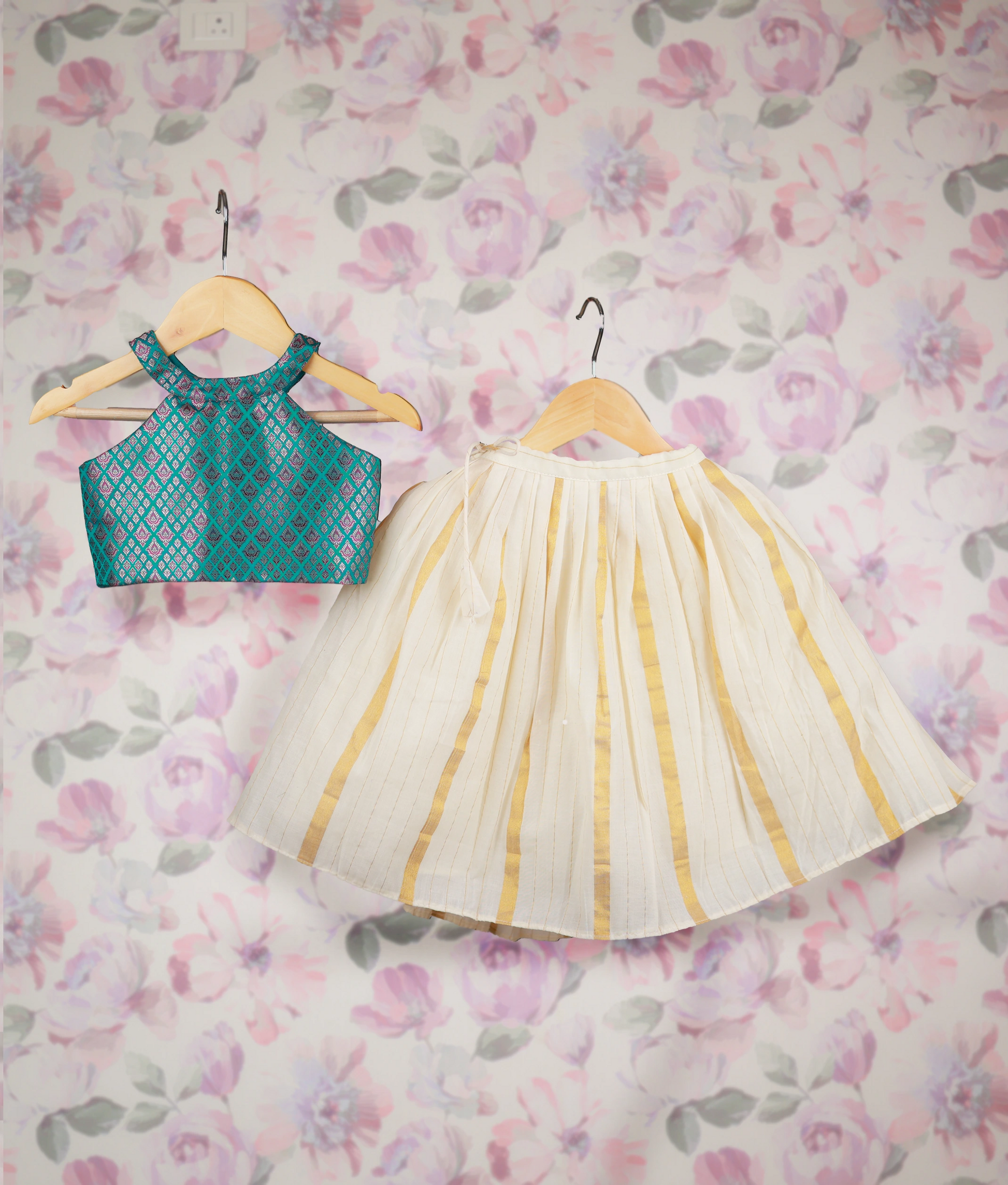 Traditional kids' outfit with a Banarasi top and off-white skirt with golden stripes on hangers