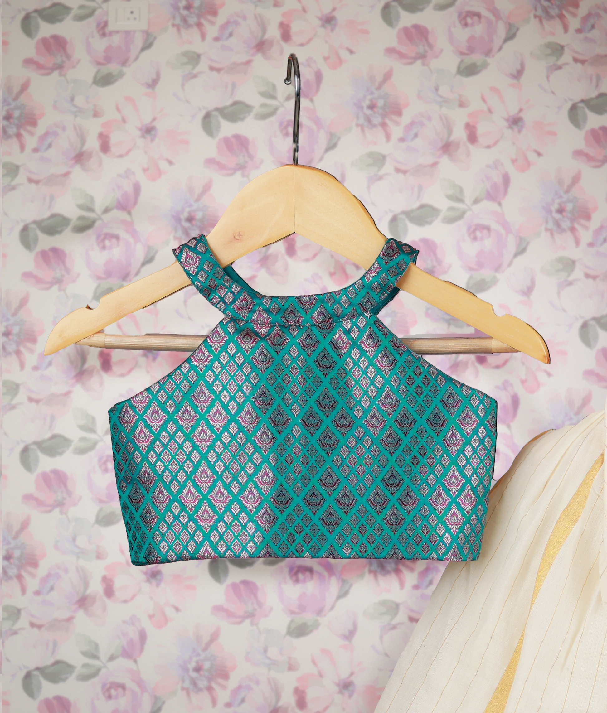 Close view of an traditional kids' outfit with a Banarasi top and off-white skirt with golden stripes on hangers