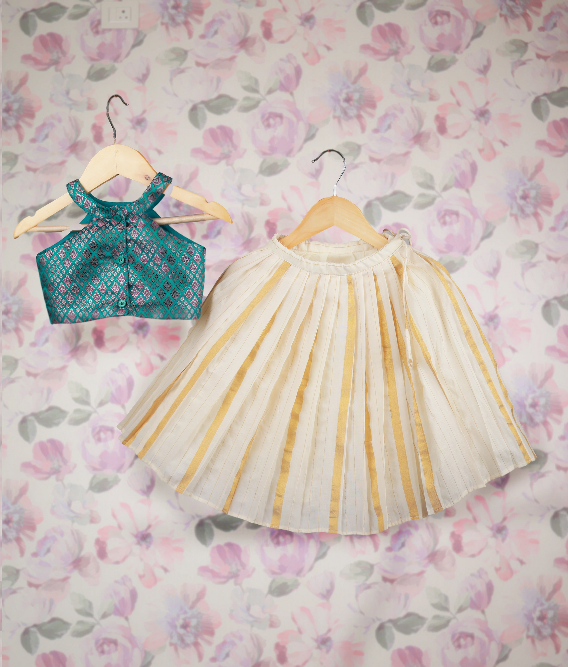 Back view of an traditional kids' outfit with a Banarasi top and off-white skirt with golden stripes on hangers