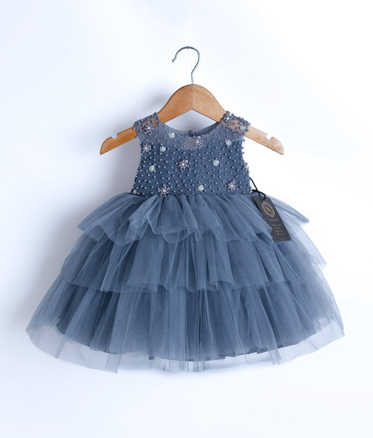 A sleeveless, ash gray tulle net frock displayed on a hanger.
