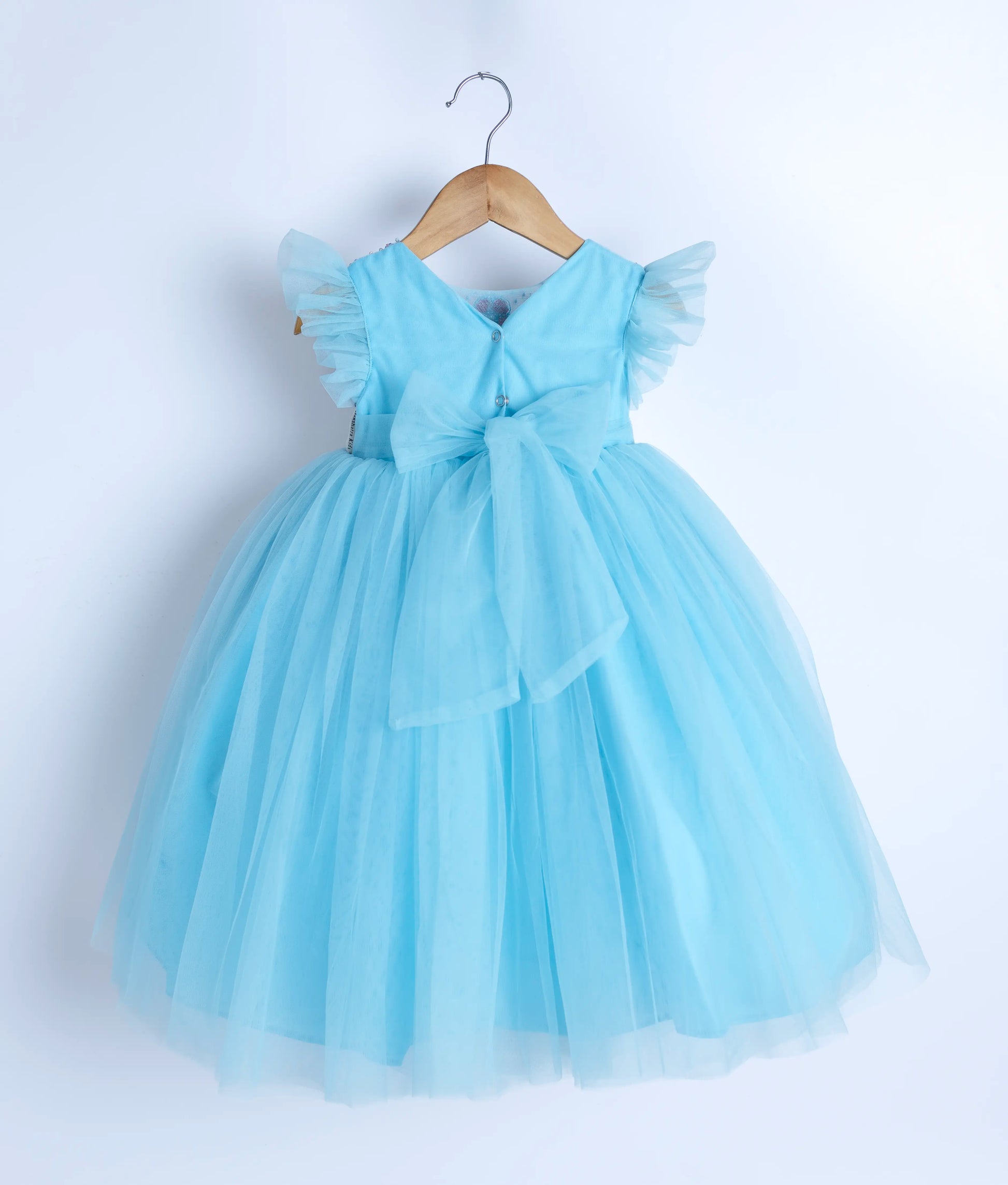 Back view of an blue tulle net frock displayed on a hanger.