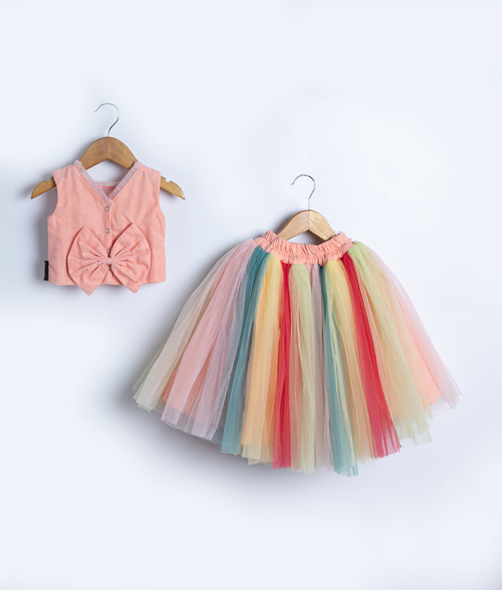 Back view of an peach top with multicolor tulle skirt is displayed on hangers.