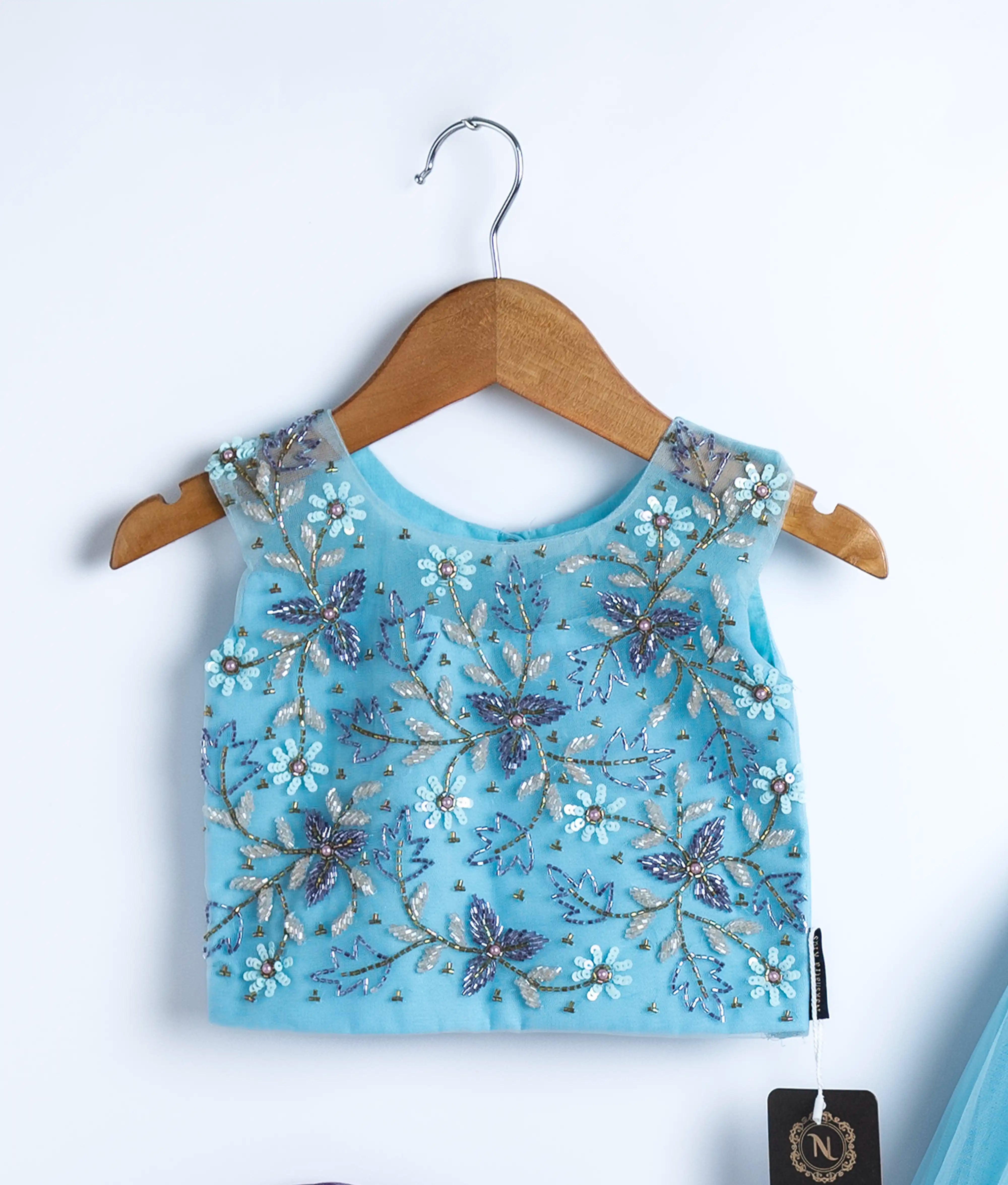 Close view of an sky blue tulle net handworked crop top.