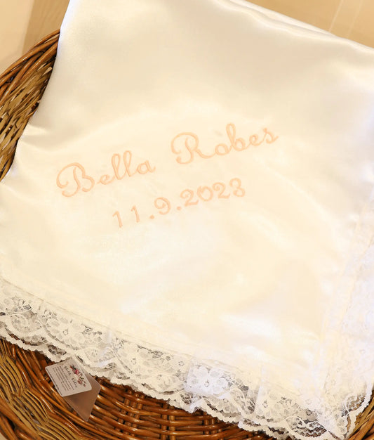 Close view of a white satin customized embroidery baptism towel.