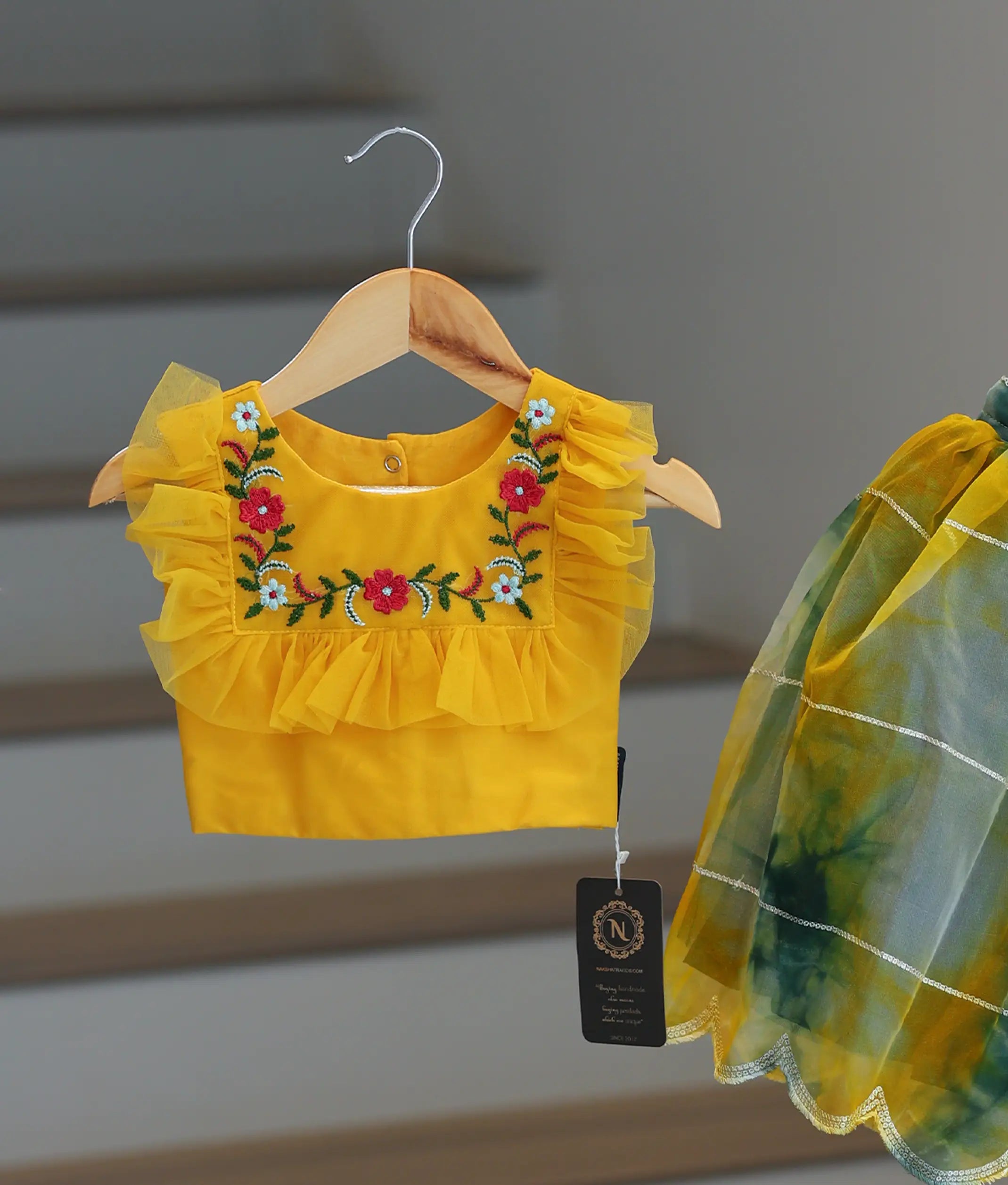Close view of a yellow top with Green and yellow organza skirt.