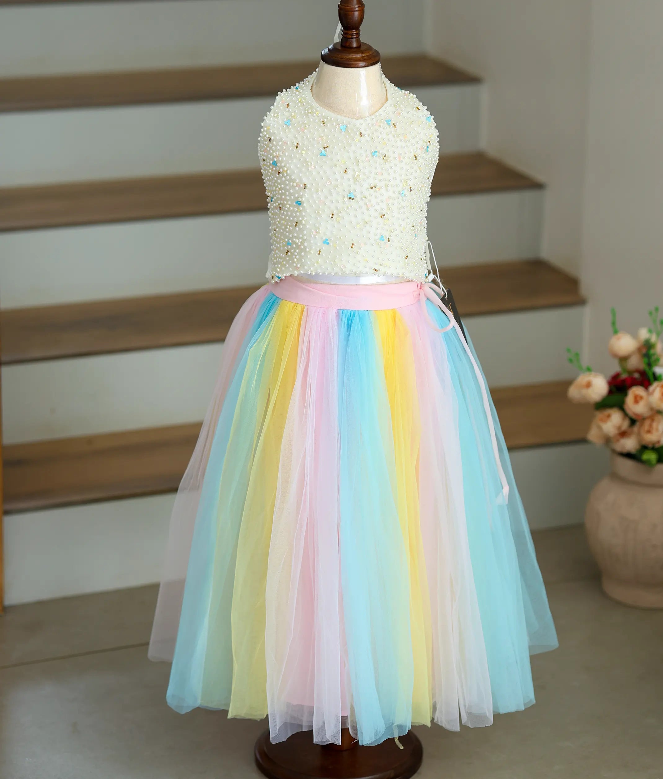 Front view of an off-white top with a multicolor skirt on a mannequin.