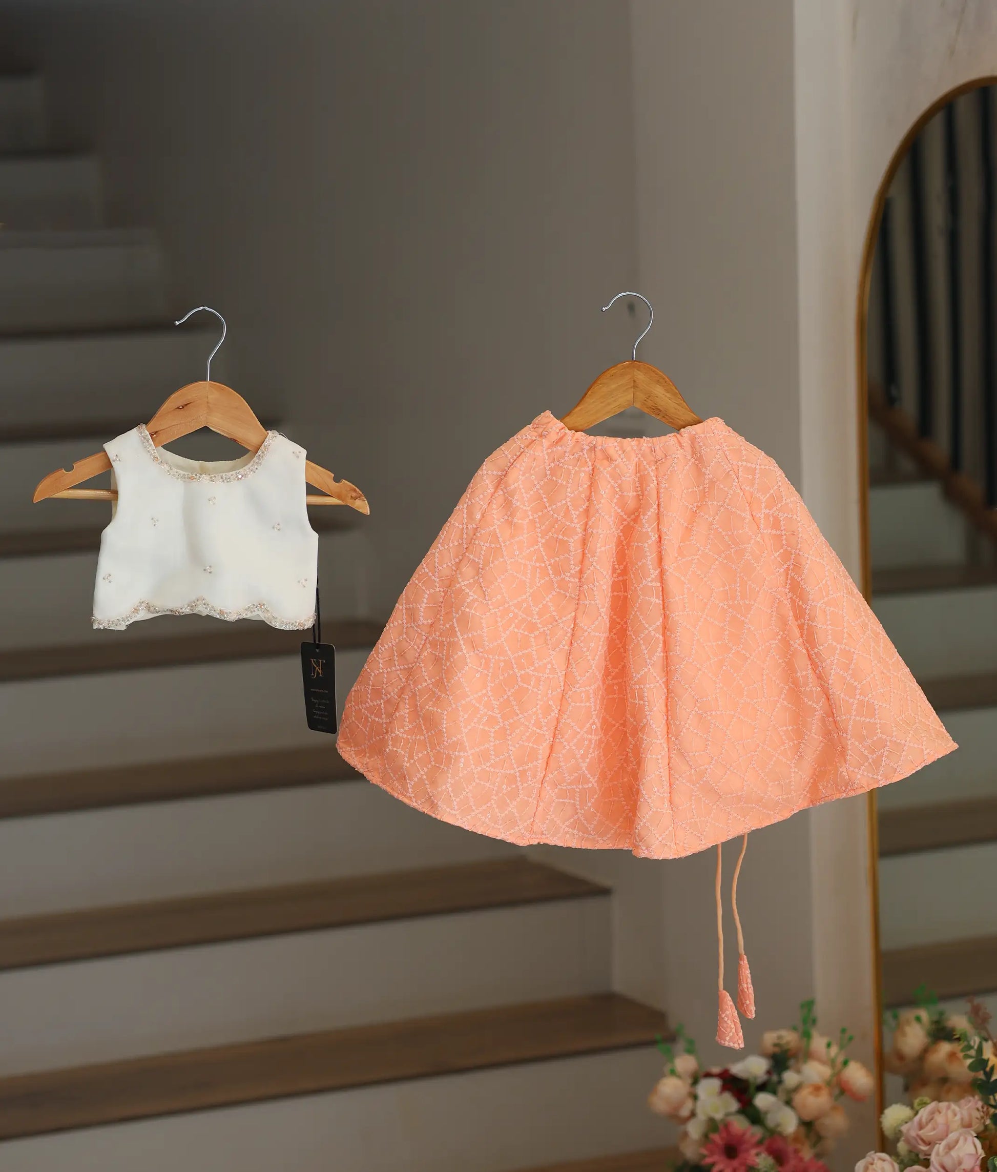 Front view of off white top and peach skirt 