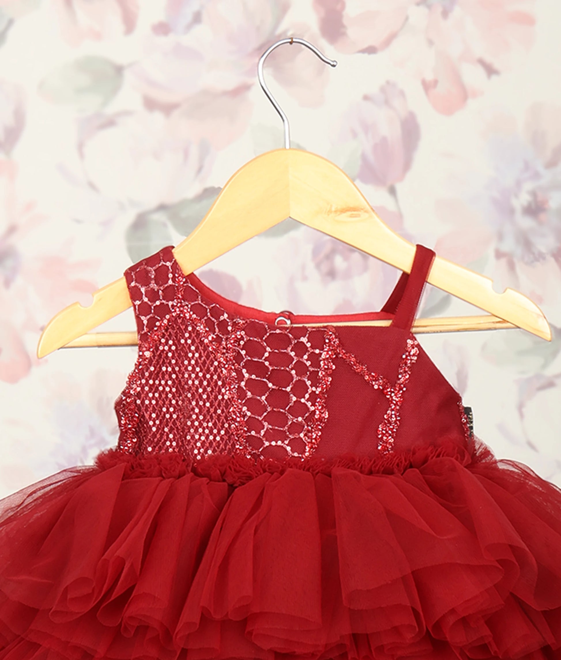 Close view of maroon tiered tulle baby frock with work material yoke and ruffled skirt for parties
