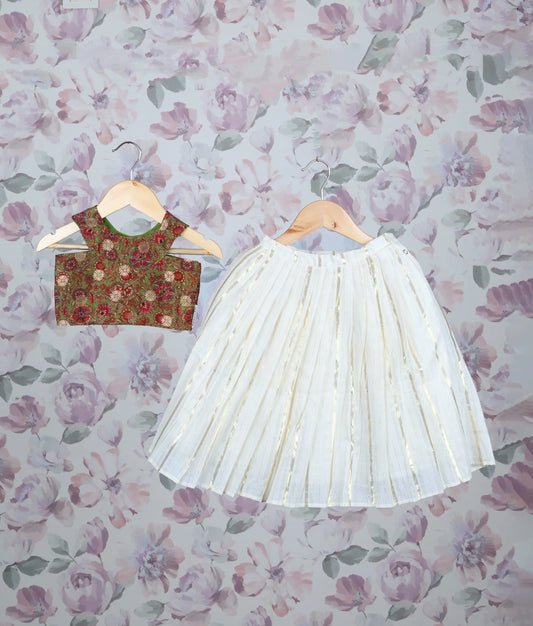 Festive outfit with an olive green floral print top and off-white pleated skirt with golden stripes.