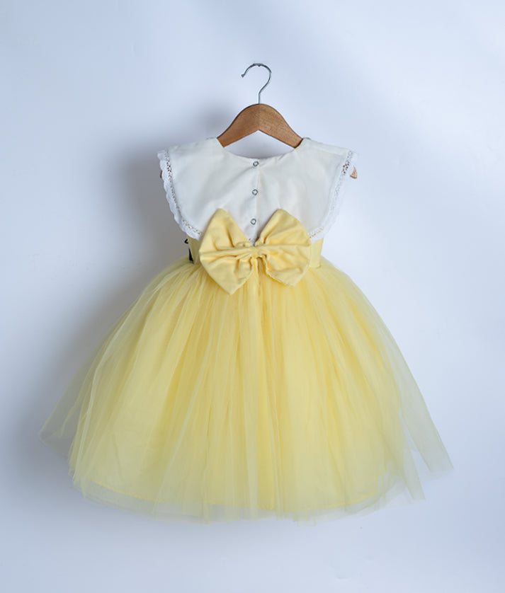 Back view of an off-white and yellow frock displayed on a hanger.