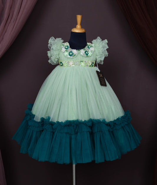 A pastel green tulle net birthday gown displayed on a mannequin.
