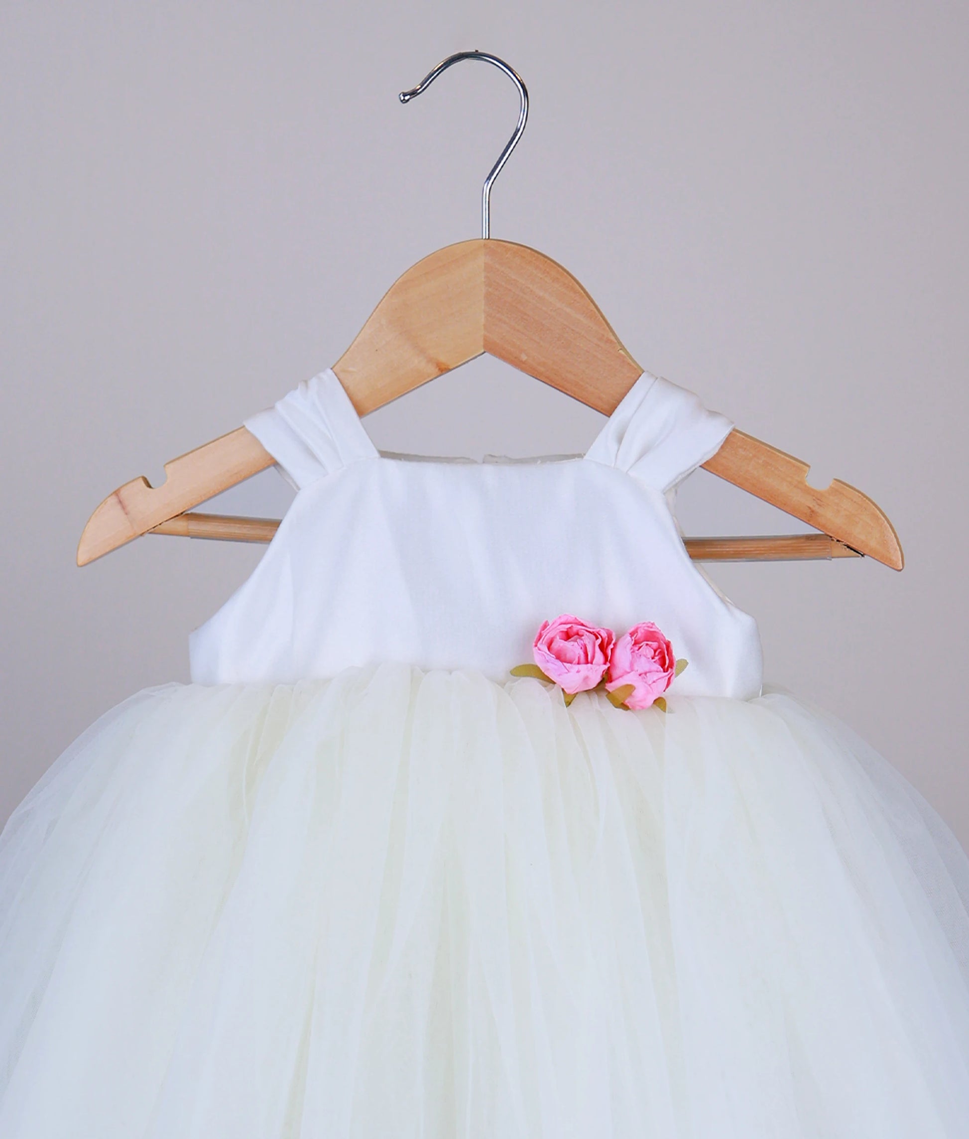 Close view of an off-white tulle net birthday frock against a white background.