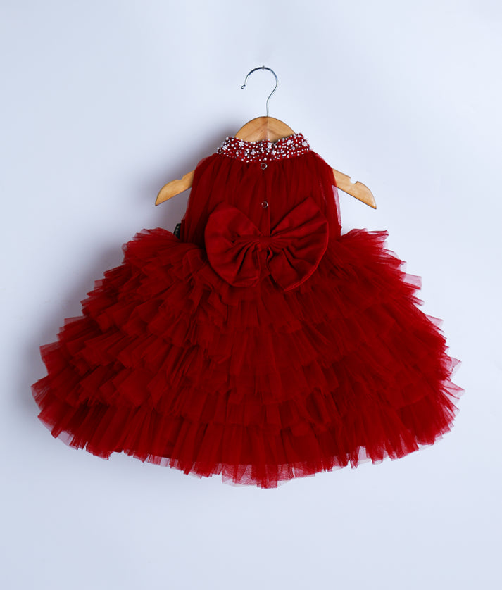 Back view of an maroon-colored frock on a wooden hanger.
