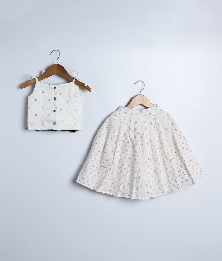 Back view of an black georgette crop top and a chanderi skirt displayed on hangers against a white background.