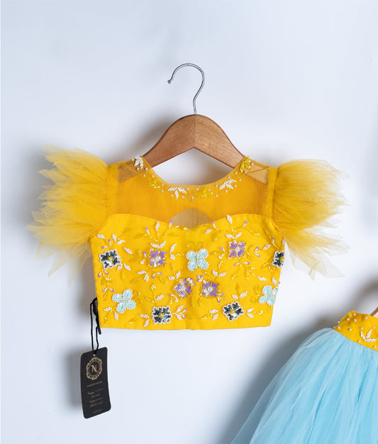 Close-up of yellow floral baby dress top with feather detailing