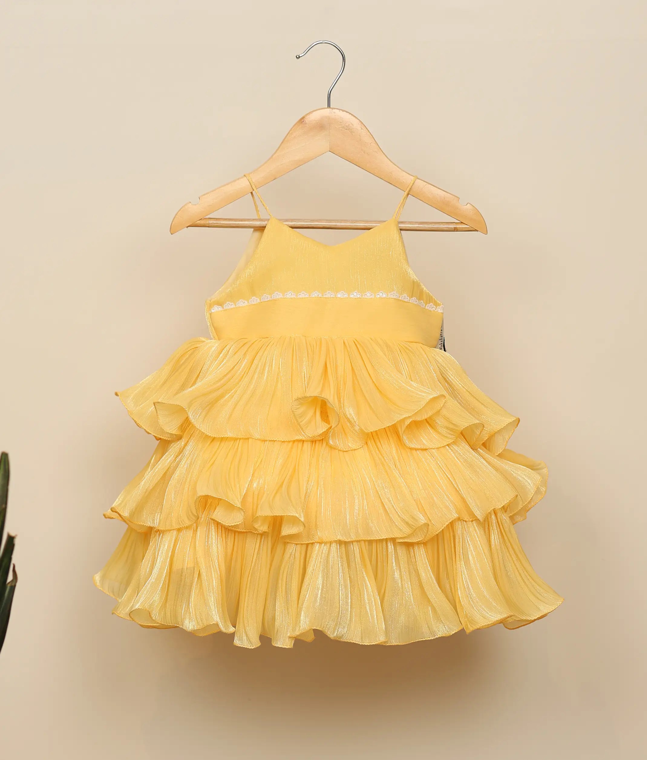 Front view of a vibrant yellow laser organza birthday dress for baby girls featuring spaghetti straps and a multi-layered step skirt