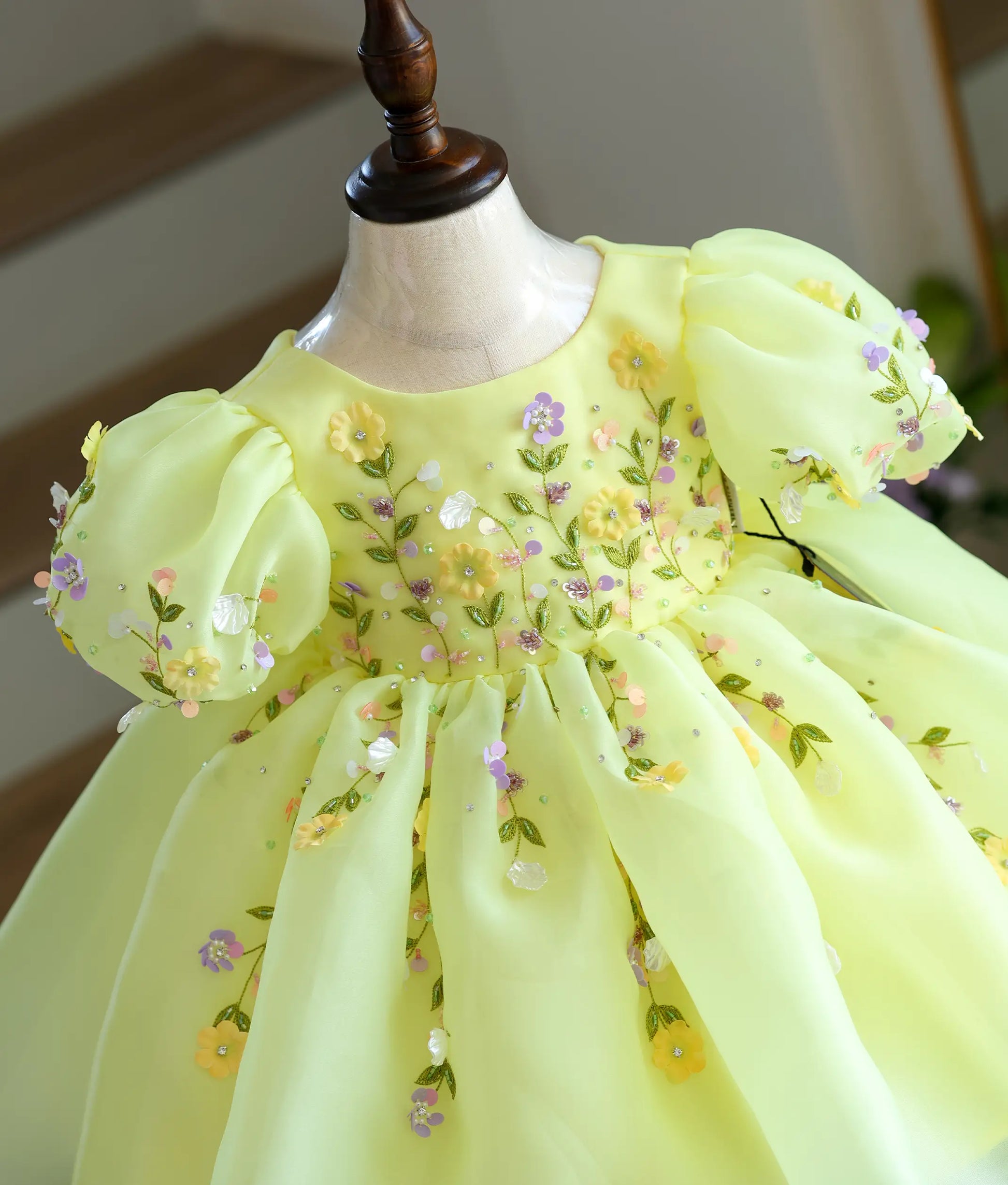 Close-up of floral embroidery detail on yellow organza birthday frock for baby girl