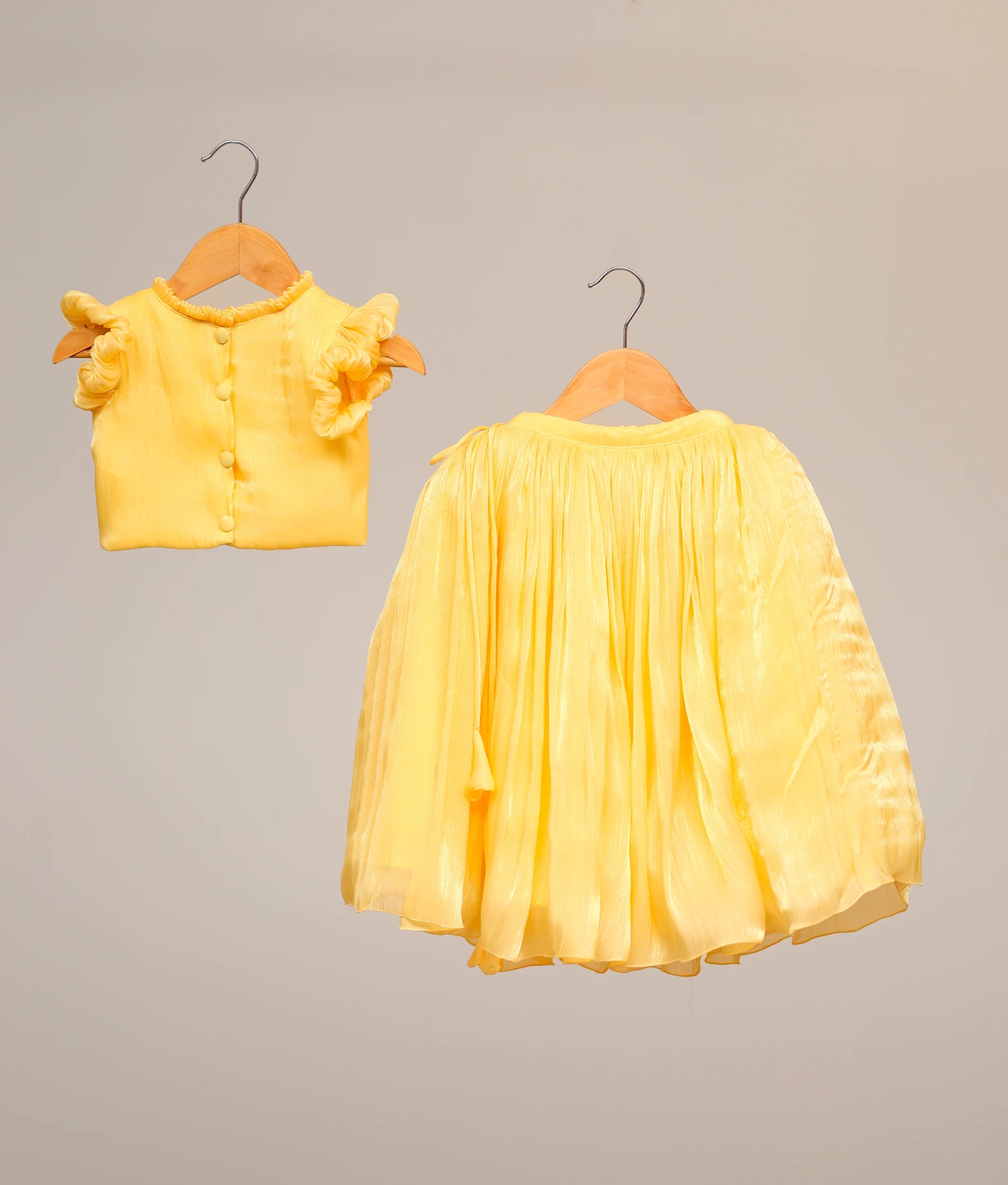 Back view of the yellow baby girl skirt and top set showing the round neck and full-length skirt